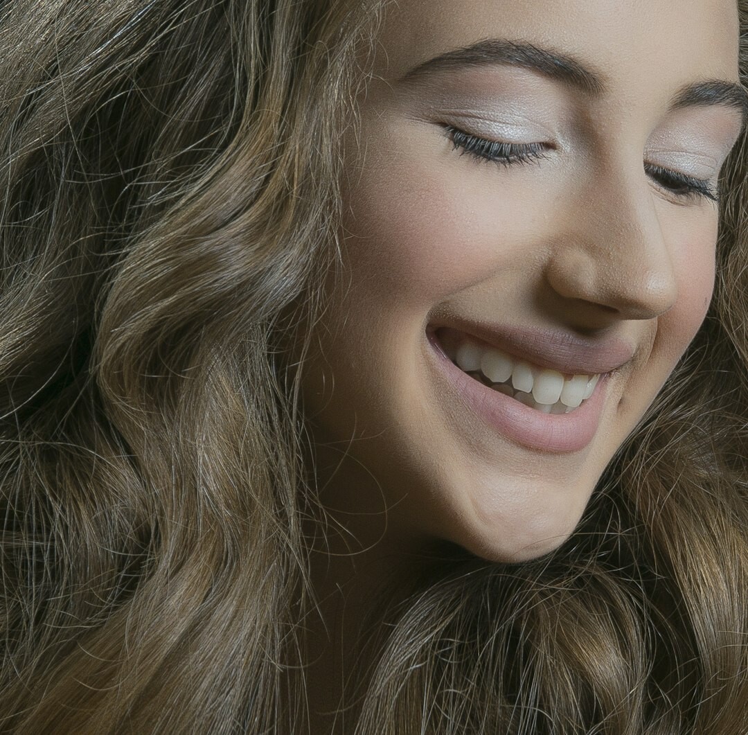Studio portrait of a woman with curly hair smiling